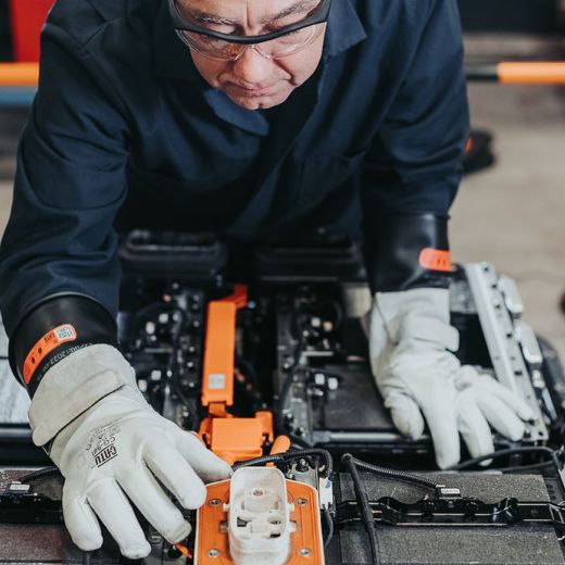 Un homme verifiant une voiture électrique dans un garage.